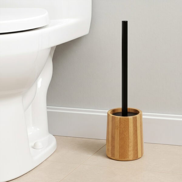 Bamboo toilet brush holder with black handle beside white toilet