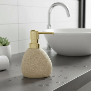 Sponge texture soap dispenser with gold pump on bathroom countertop near sink