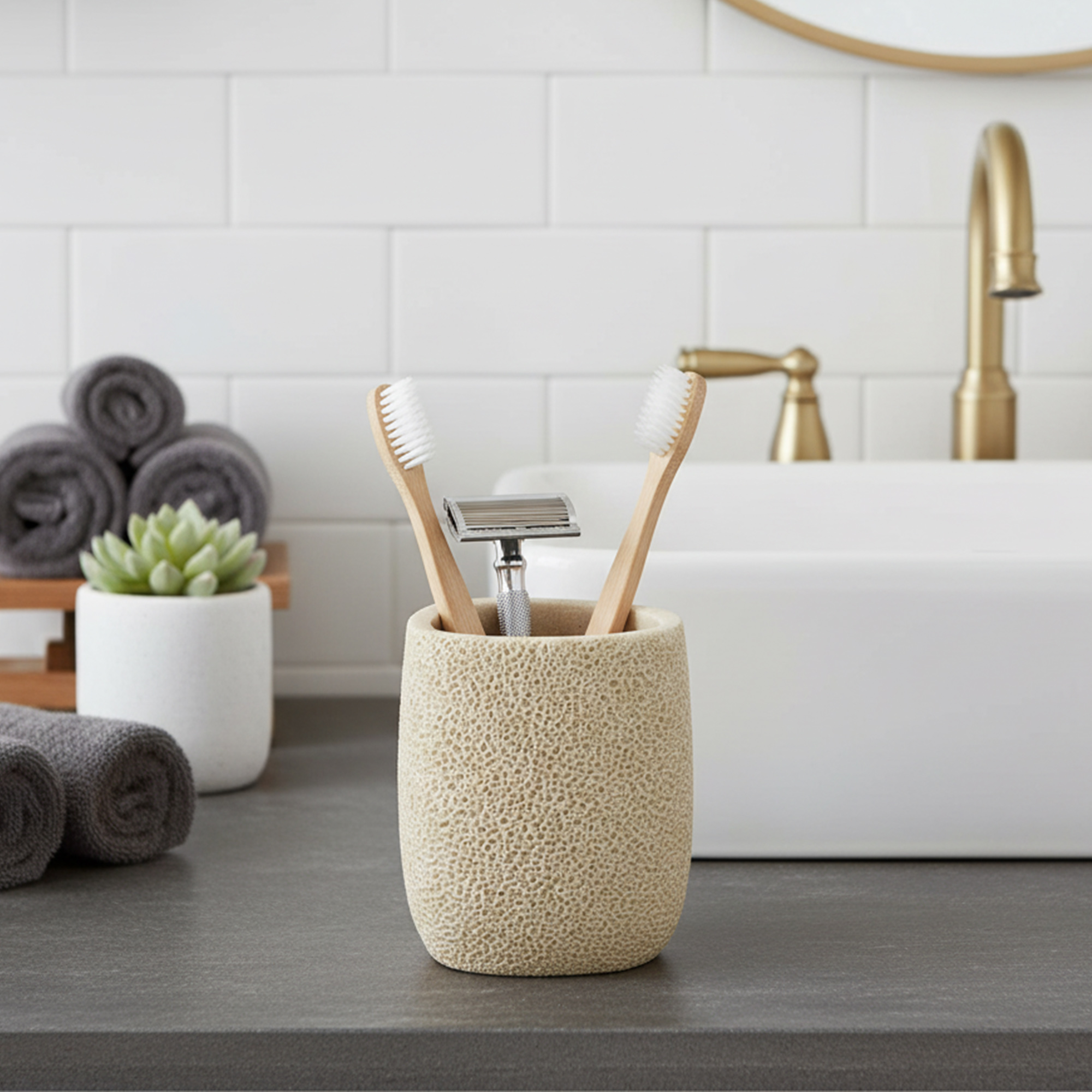 Beige sponge texture tumbler toothbrush holder with bamboo brushes on vanity
