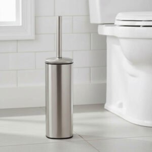Brushed stainless steel square toilet brush with chrome handle beside white toilet in tiled bathroom