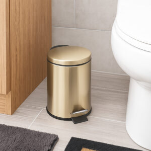 Gold trash can next to cabinet on bathroom floor compact size