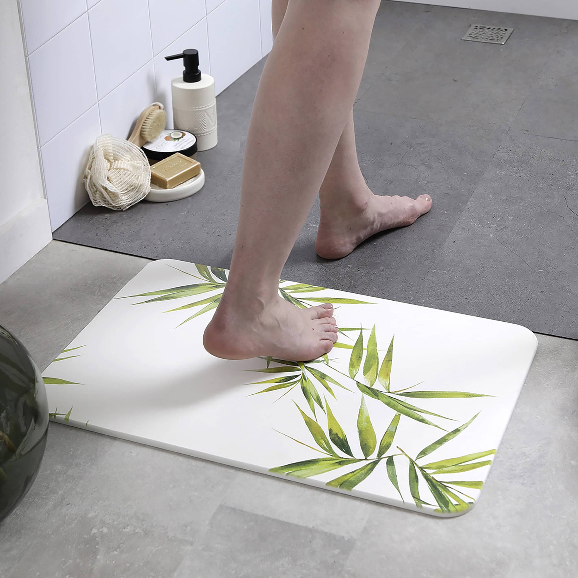 Person standing on a bamboo-patterned diatomite bath mat in a modern bathroom