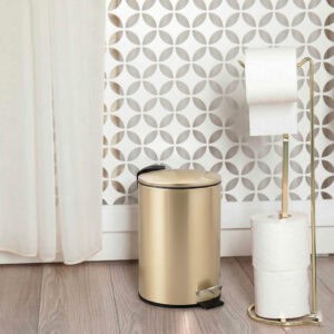 Gold trash can near toilet on tiled floor bathroom scene
