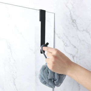 black shower hook in situation on a glass door with hand hanging bath sponge