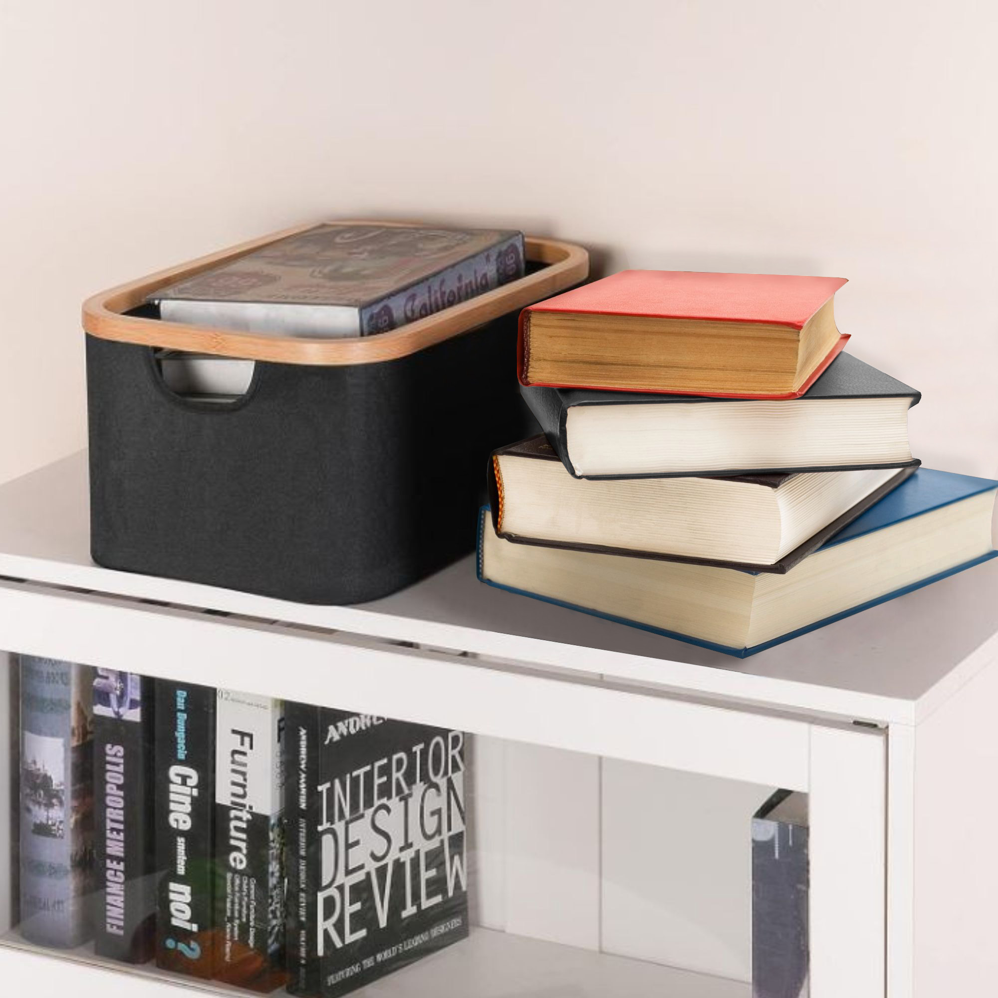 Black Oxford fabric storage basket with natural bamboo rim, holding books on a white shelf beside a stack of colorful books.