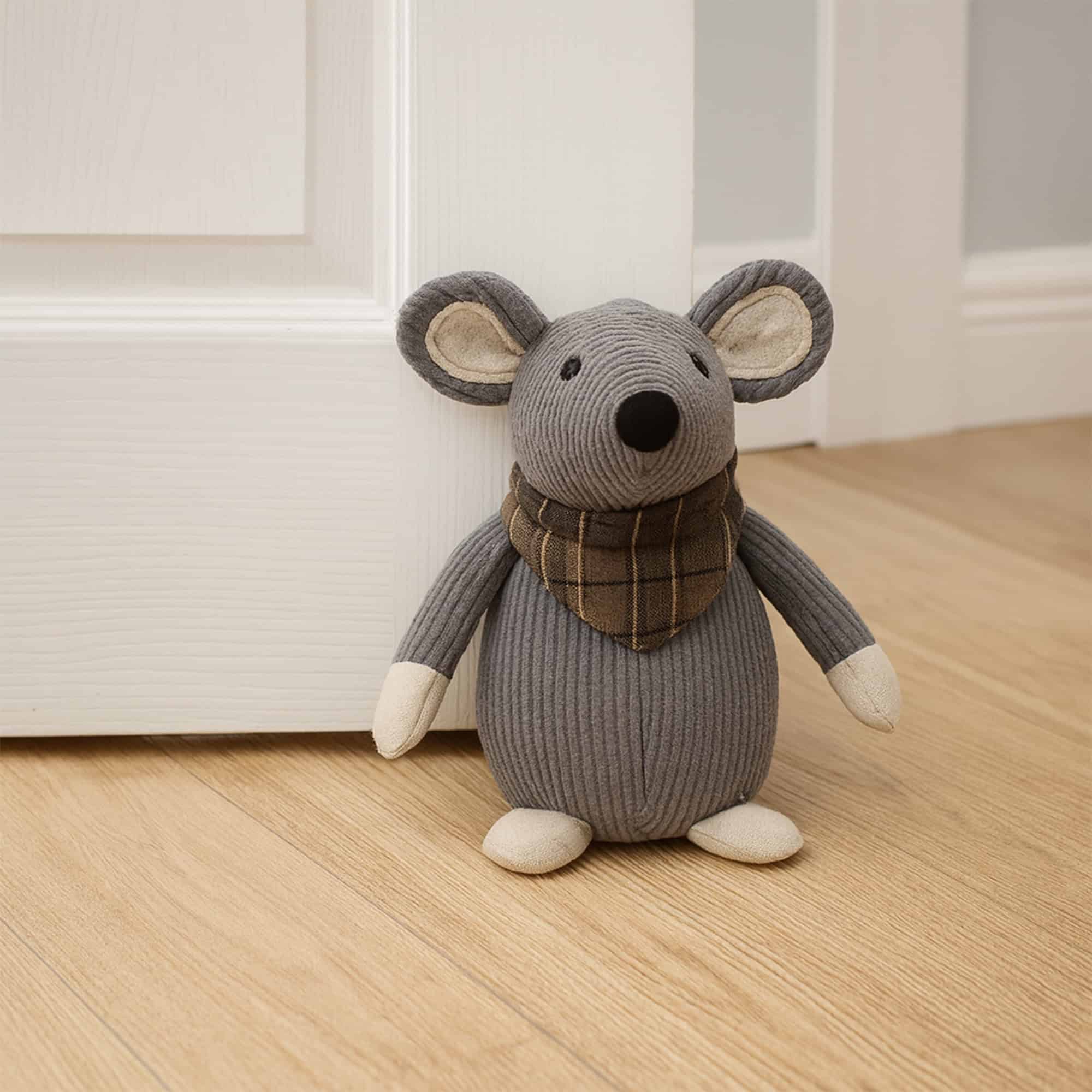 Grey mouse door stopper propping open a white paneled door on hardwood floor.
