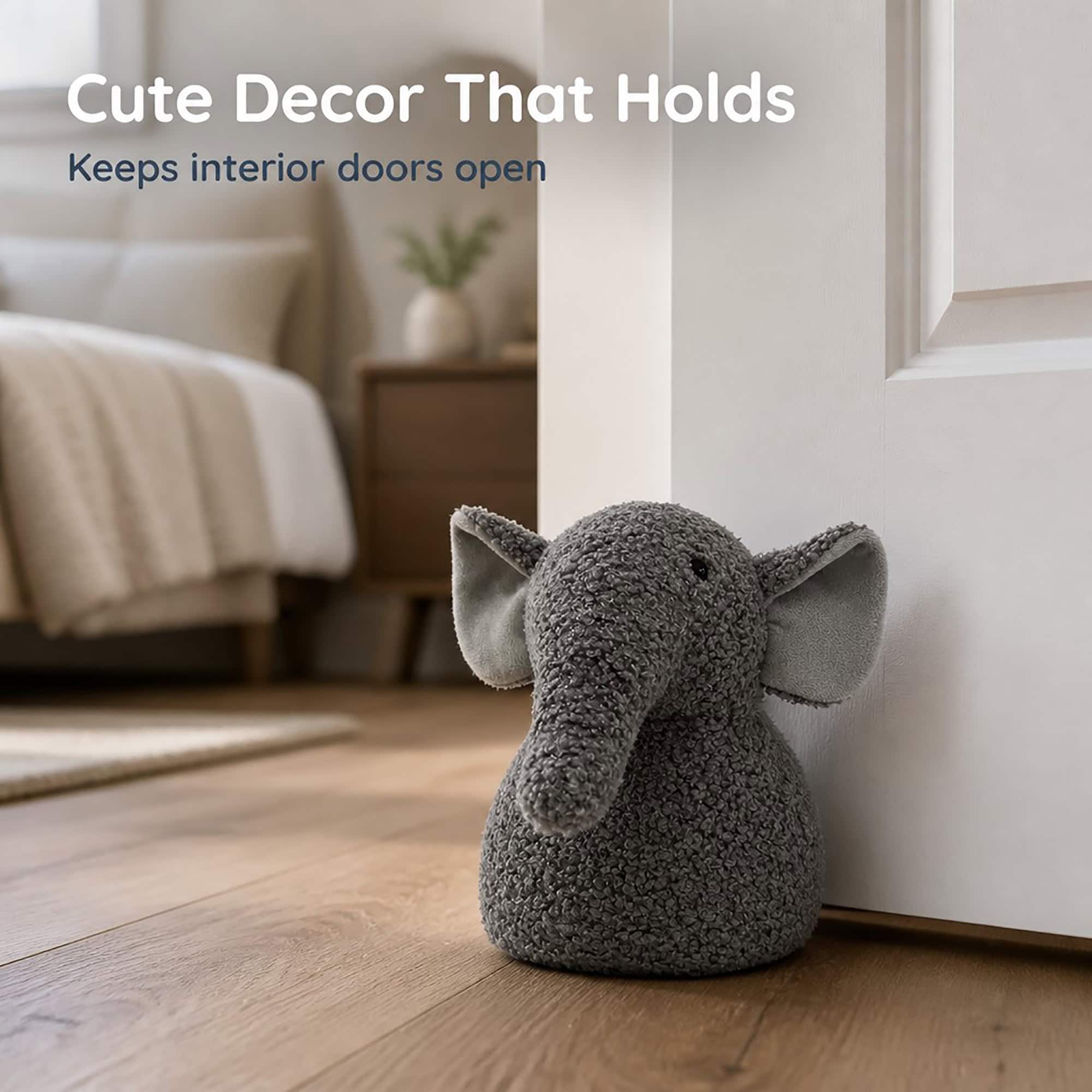 Grey elephant door stopper propping open a white paneled door on hardwood floor, bed and nightstand in the background. On-image text: "Cute Decor That Holds," "Keeps interior doors open."