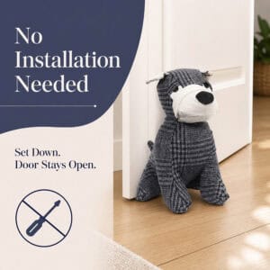 Charcoal plaid dog door stopper holding open a white door on hardwood floor, with a crossed-out screwdriver icon. On-image text: "No Installation Needed," "Set Down. Door Stays Open."