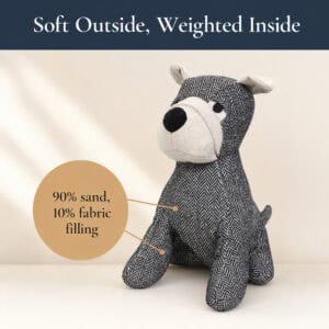Charcoal dog door stopper on a cream background with a callout circle. On-image text: "Soft Outside, Weighted Inside," "90% sand, 10% fabric filling."