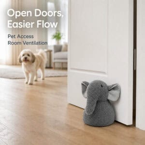 Grey elephant door stopper propping open a white door on hardwood floor, with a small dog approaching in the background. On-image text: "Open Doors, Easier Flow," "Pet Access," "Room Ventilation."