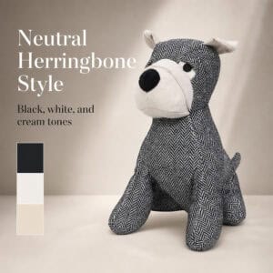 Charcoal dog door stopper on a taupe background with a black, white, and cream swatch bar. On-image text: "Neutral Herringbone Style," "Black, white, and cream tones."