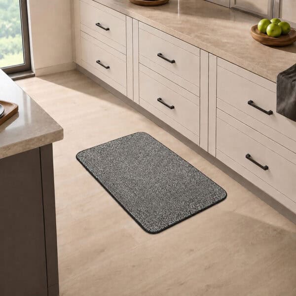 Charcoal grey kitchen mat placed in front of a sink in a bright modern kitchen, adding cool neutral contrast to the floor.