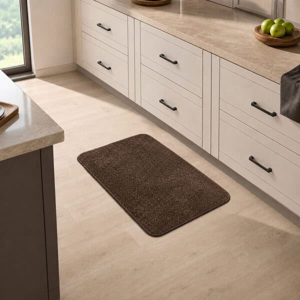 Chocolate brown kitchen mat placed in front of a sink in a bright modern kitchen, adding warm decorative contrast to the floor.