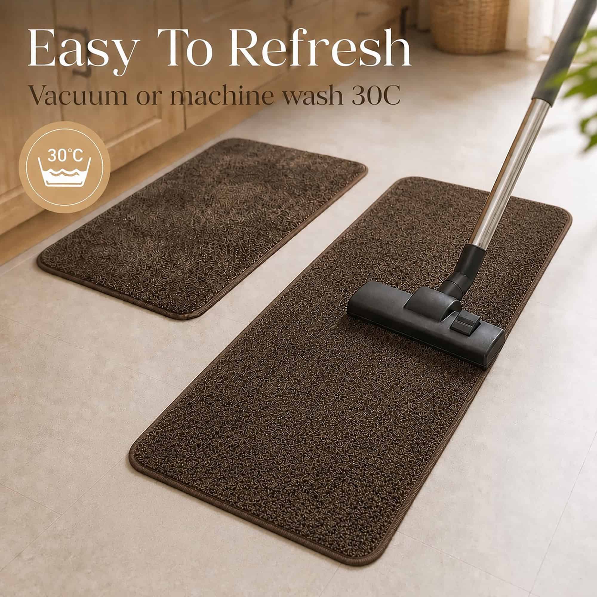 Chocolate brown kitchen rug set being vacuumed in a laundry area, illustrating easy care with machine wash or vacuum cleaning.