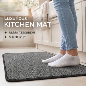 Person in socks standing on a soft charcoal grey kitchen mat by a cabinet, highlighting ultra absorbent and super soft comfort underfoot.