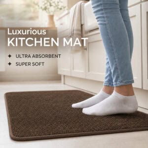Person in socks standing on a plush chocolate brown kitchen mat by a cabinet, highlighting ultra absorbent and super soft comfort underfoot.