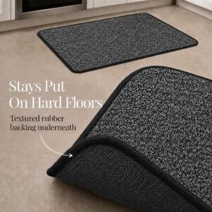 Charcoal grey kitchen mat and runner with a corner lifted to reveal the textured rubber backing that stays put on hard floors.