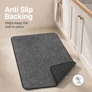 Charcoal grey kitchen mat with a corner flipped up to reveal the textured rubber non-slip backing that grips hard floors and stays in place.