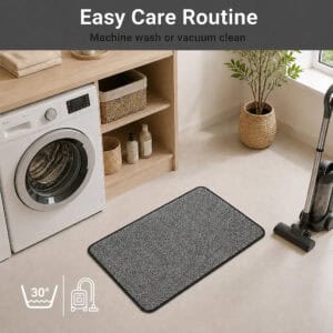 Charcoal grey kitchen mat in a laundry room beside a vacuum, illustrating easy care with machine wash or vacuum cleaning.