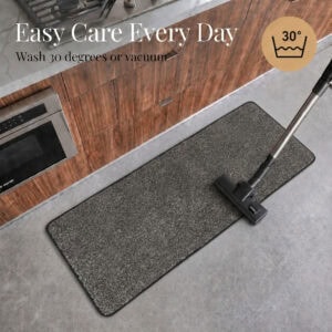 Charcoal grey kitchen runner beside a vacuum, illustrating easy care with machine wash at 30 degrees or vacuum cleaning.