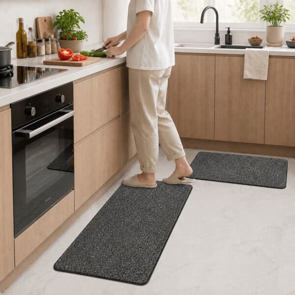 Charcoal grey kitchen mat and runner set arranged in front of a farmhouse sink, grounding the space with cool neutral tones.
