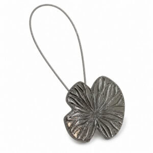 Hero: Polished graphite water lily leaf magnetic curtain tieback with carved veins and a thin steel cable