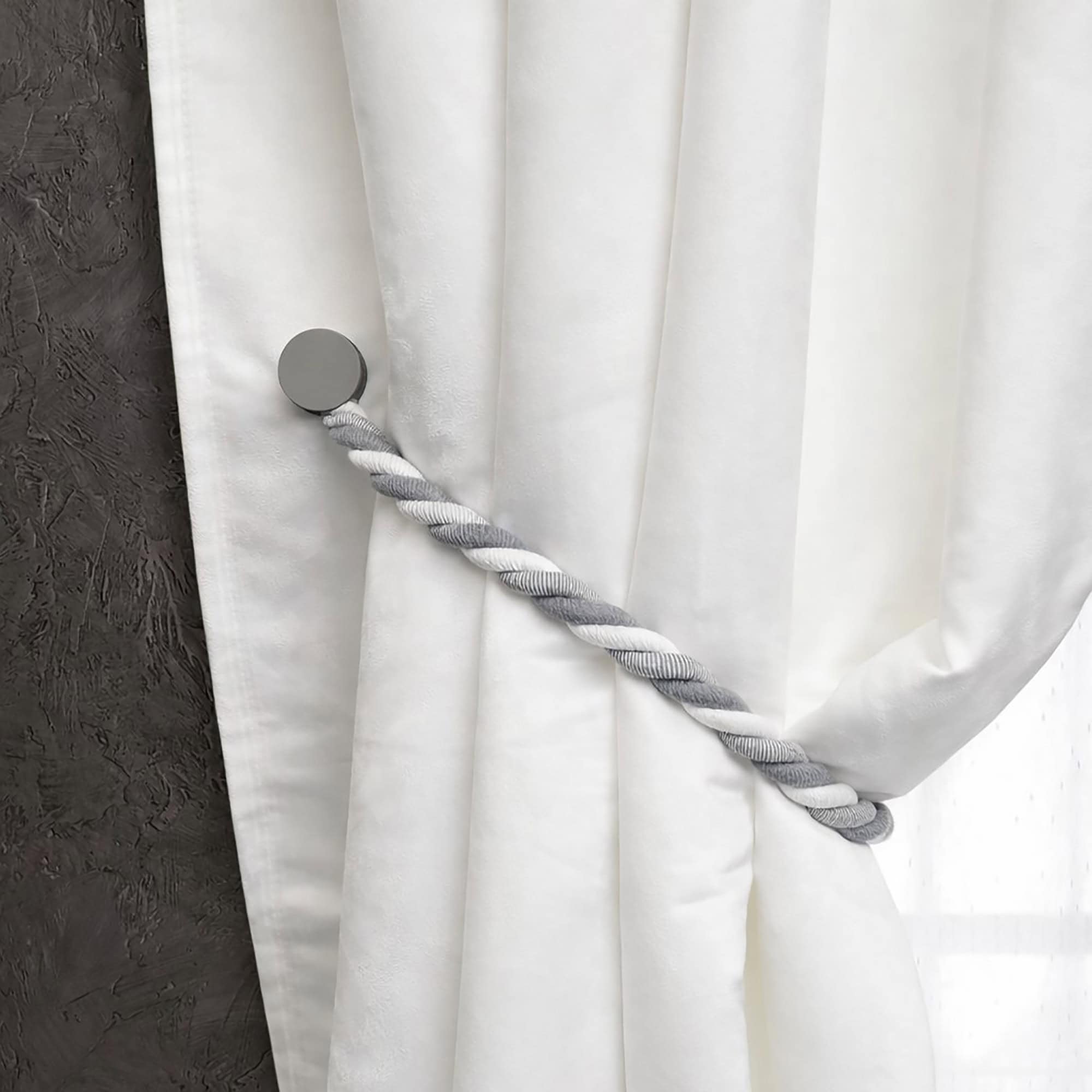 Single gray braided tieback with round magnetic clasp on white curtain