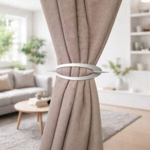 "Silver minimalist oval curtain tieback on taupe curtains in a Scandinavian-style living room"