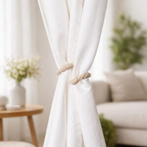 "Ecru rope tieback holding white curtain panels together in a bright living room"