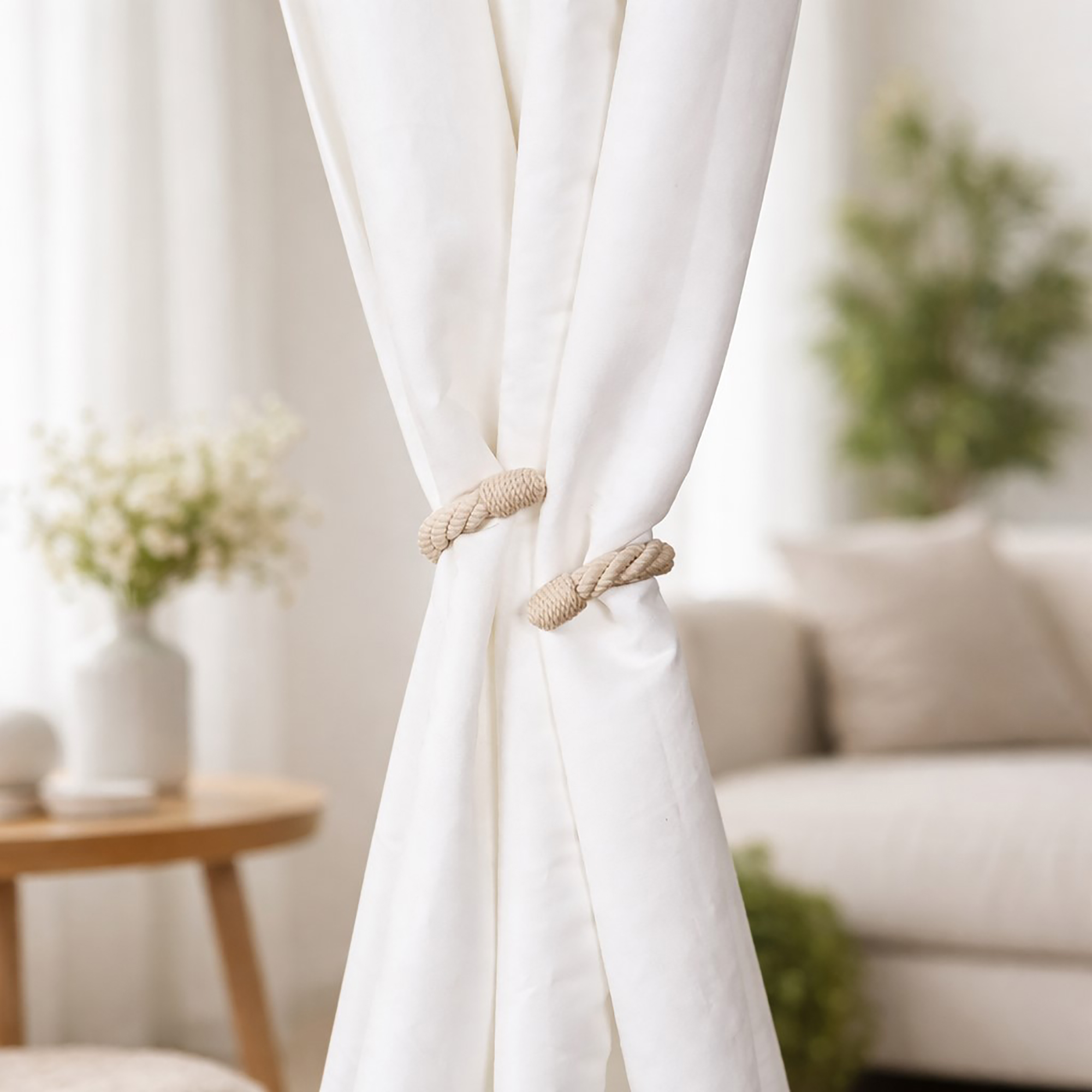 "Ecru rope tieback holding white curtain panels together in a bright living room"