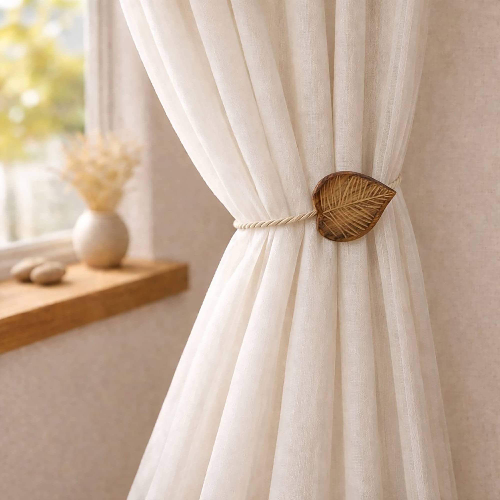 Natural wood leaf tieback holding sheer curtain by sunny window