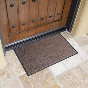 Tan outdoor front door mat on stone entry for heavy traffic use