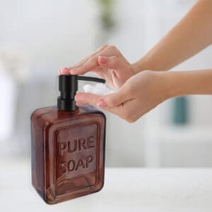 Hand Pump Operation on Amber Glass Soap Dispenser for Convenient Use – A person pressing the black pump on the amber glass soap dispenser, demonstrating a smooth and convenient hand-pump function.