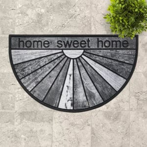 Stylish Monochrome Welcome Mat Displayed Outdoors: A modern outdoor patio featuring the "Home Sweet Home" monochrome doormat complemented by decorative plants.