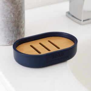 Navy blue soap dish with slotted bamboo insert on bathroom sink