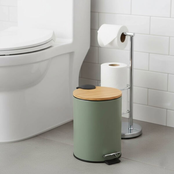 Green step trash can with bamboo lid next to toilet