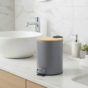 Gray step trash can with bamboo lid on bathroom countertop