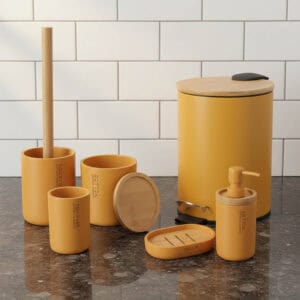 Mustard yellow 6-piece bathroom accessory set with bamboo lids and accents displayed on a marble countertop