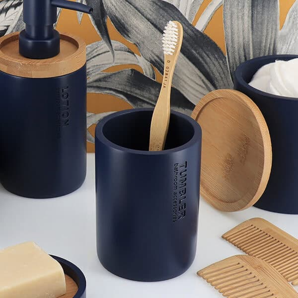 Toothbrush holder in a navy blue finish with bamboo accents in the background