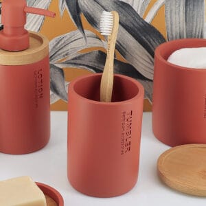 Toothbrush holder in a red finish with bamboo accents in the background