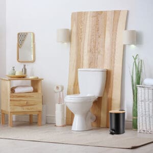 A black step trash can with a bamboo lid placed in a bathroom with natural wood accents, complementing the serene and modern décor.