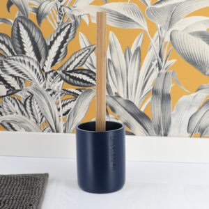 Navy blue toilet brush and holder displayed on bathroom floor with botanical wallpaper backdrop