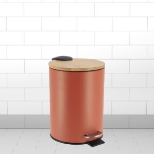 A red step trash bin with a bamboo lid and soft-close feature, placed in a tiled bathroom setting.