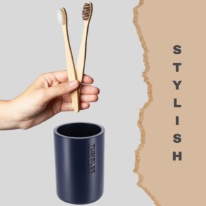 Close-up of a navy tumbler paired with bamboo toothbrushes