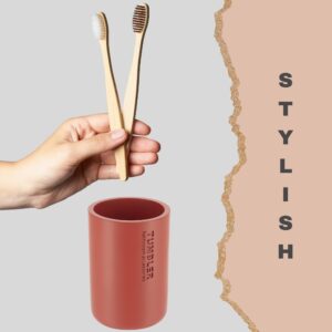 Close-up of a red tumbler paired with bamboo toothbrushes