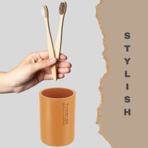 Close-up of a yellow tumbler paired with bamboo toothbrushes