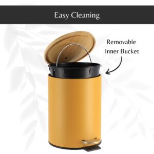 Mustard yellow step trash can with its bamboo lid open, revealing a removable inner bucket with a handle for hassle-free cleaning and maintenance.