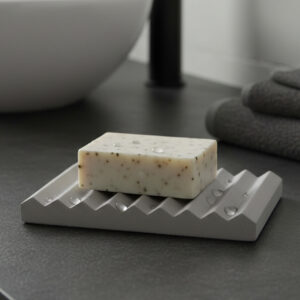 Gray ribbed soap dish holding bar soap on bathroom counter