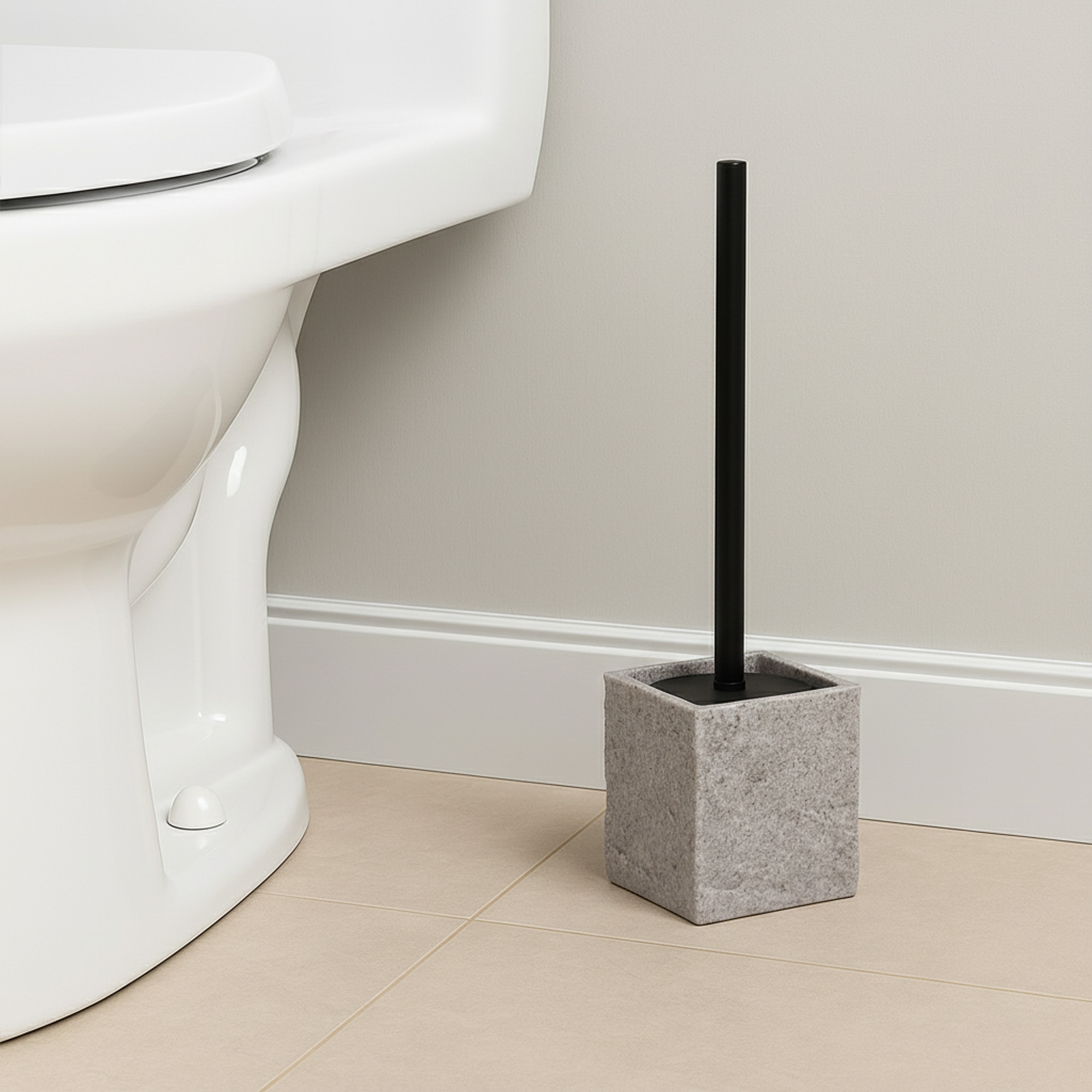 Gray stone effect toilet brush holder with black handle beside white toilet