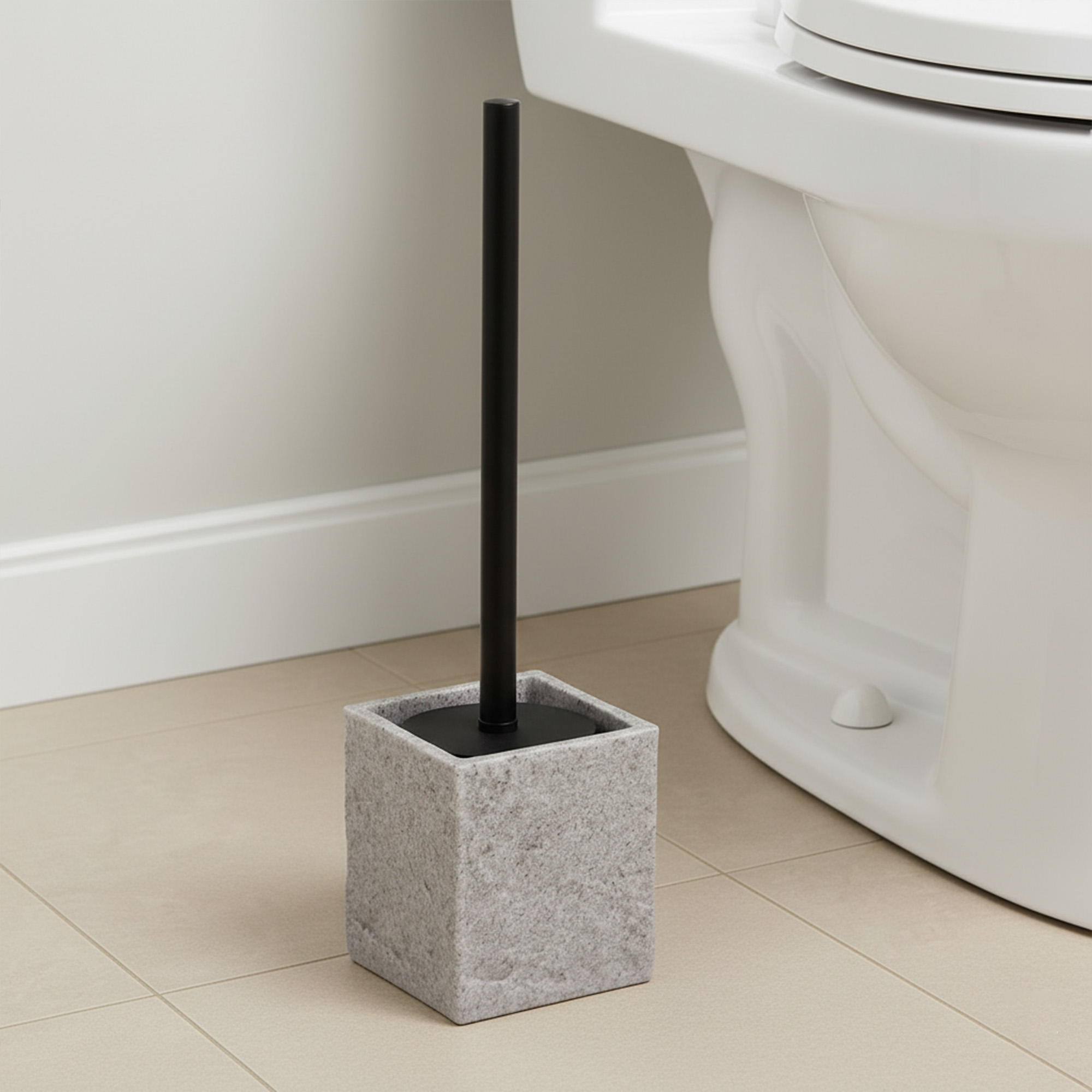 Gray stone effect toilet brush holder next to white toilet